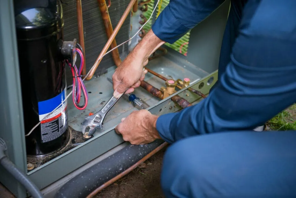 Electrician bending down and fixing wires.