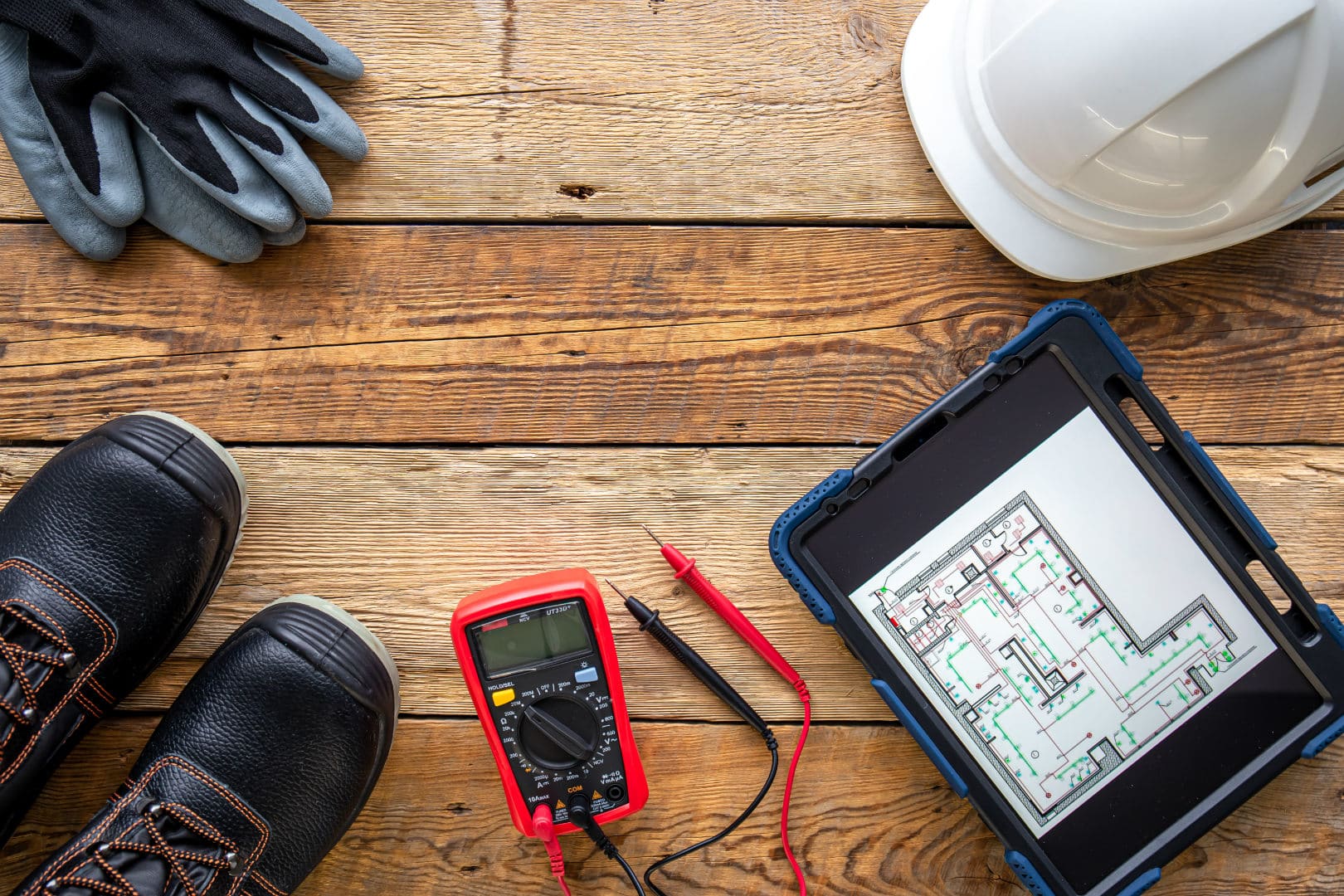 Electrician gloves, boots, hard hat, and meter.