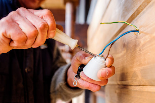 Electrician working with wires and a screw driver.