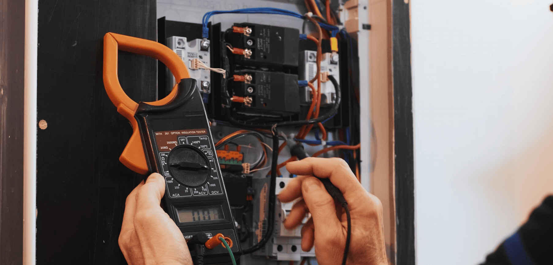 Picture of a person's hands fixing residential electrical equipment.